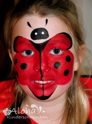 Ladybird face paint art with red and black details