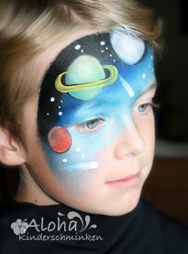 Planet-themed face makeup design with colorful imaginative details